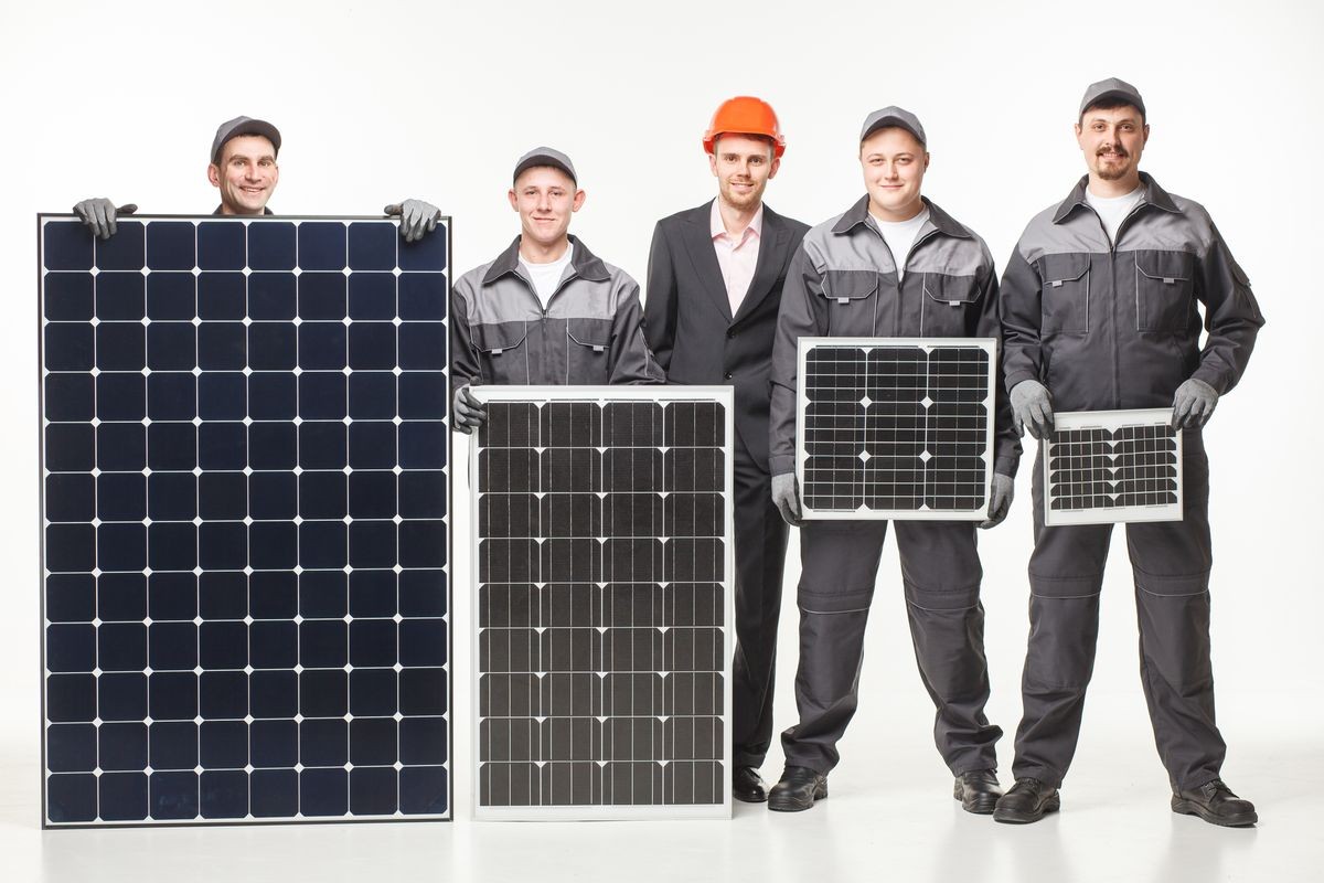 team working with a variety of solar panels white studio background